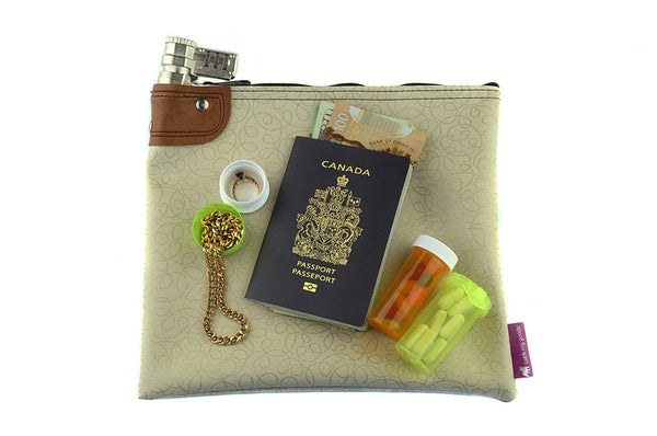 Creme coloured combination locking bag shown with jewelry, passport, money and medication. 