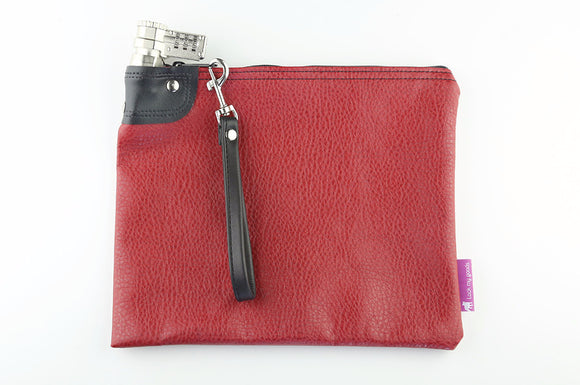 Cranberry red, locking bag with combination lock, and black wrist strap.  