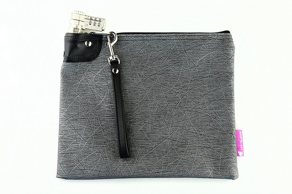 Gray vinyl bag with black and silver design pattern, shown with smart phone, medication, passport and jewelry, and wrist strap. 