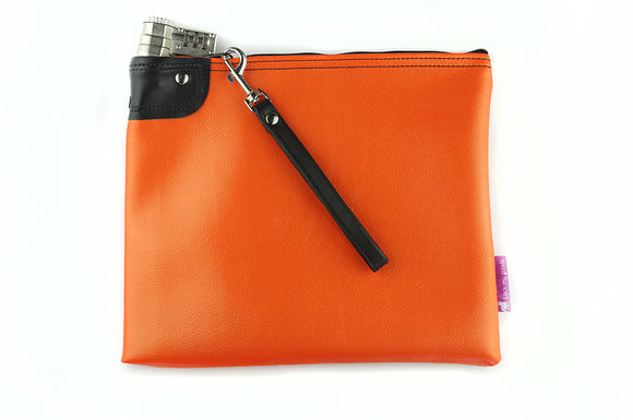 Bright orange, locking medication and travel bag, show with leather wrist strap.  Used to lock up medication and travel safety.