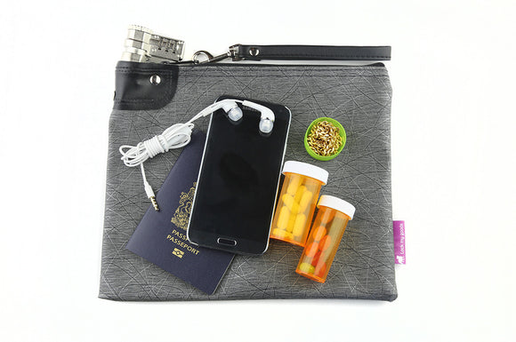Gray vinyl bag with black and silver design pattern, shown with smart phone, medication, passport and jewelry, and wrist strap. 